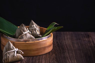 Zongzi - Çin pirinçli zongzi hamur tatlısı ahşap masa üzerinde siyah arka plan Ejderha Teknesi Festivali kutlamaları için, kapatın, kopyalayın.