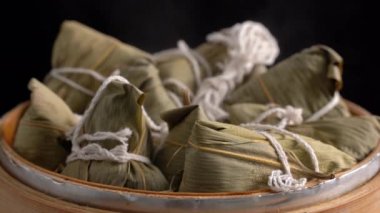 Zongzi pişirmek - Buharda pişirilmiş Çin pilavı böreği, Ejderha Teknesi Duanwu Festivali için taze yemek, siyah arka planda izole edilmiş, yaşam tarzını kapat.