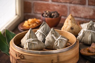 Zongzi - Çin pirinçli zongzi hamur tatlısı ahşap masada kırmızı tuğlalı, evde pencere arkası Ejderha Teknesi Festivali konsepti için, kapat.