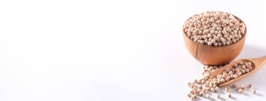 Kuru kahverengi tapyoka incileri ahşap bir kasede, beyaz arka planda izole edilmiş kaşık, yakın plan, balonlu boba sütlü çay malzemesi.