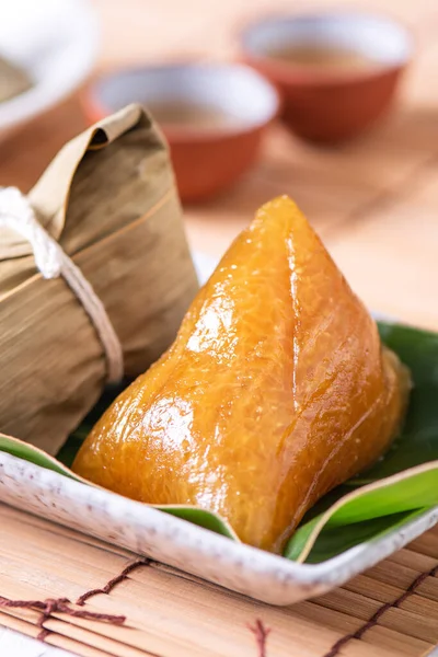 Alkaline rice dumpling zongzi - Traditional sweet Chinese crystal food on a plate to eat for Dragon Boat Duanwu Festival celebration concept, close up.