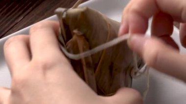 Pirinç hamurlu zongzi yemek - Genç kız evde Çin yemeği yiyor, Ejderha Teknesi Festivali için, Duanwu Festivali için, siyah ahşap masada..