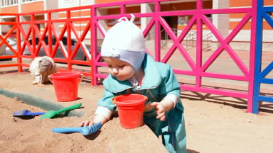 Bebek, yürümeye başlayan çocuk sandpit Kepçe kum ile oynarken