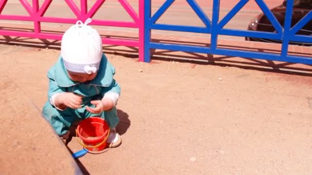 孩子在沙盒里玩沙子耙他的手 — 图库视频影像