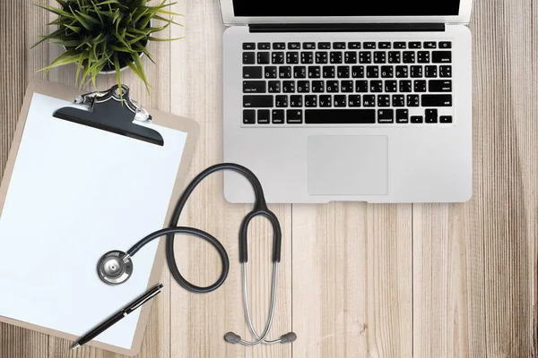 Doctor desk table with stethoscope, Laptop computer and eyeglasses, Top view