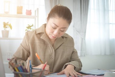 Evden çalışan Asyalı kadın.