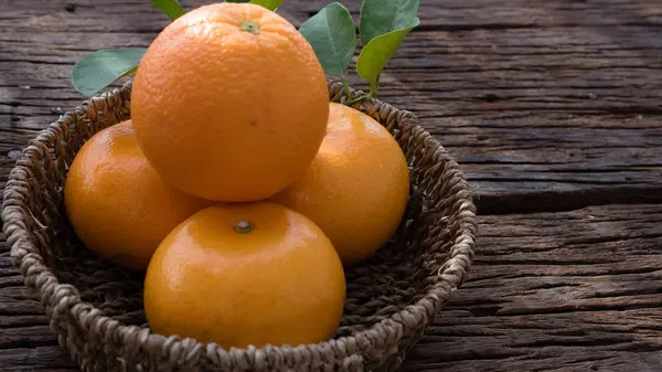 Ahşap masa ayarla turuncu meyve sepeti.