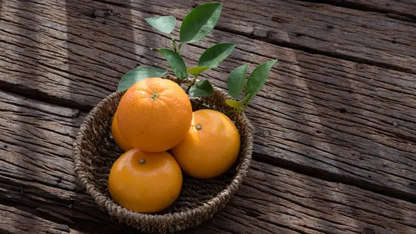 Ahşap masa ayarla turuncu meyve sepeti.