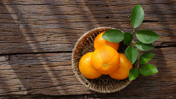 Ahşap masa ayarla turuncu meyve sepeti.