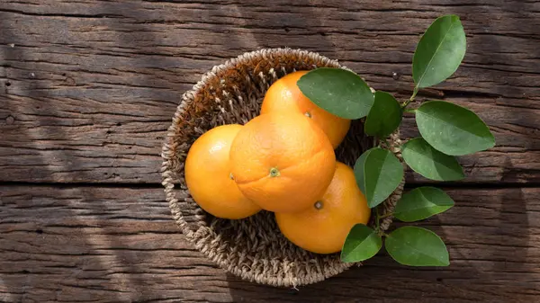 Ahşap masa ayarla turuncu meyve sepeti.