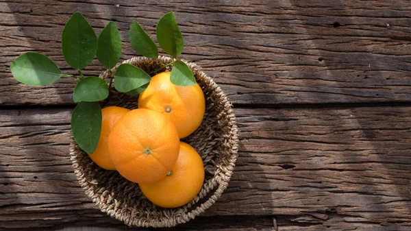 Ahşap masa ayarla turuncu meyve sepeti.