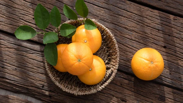 Ahşap masa ayarla turuncu meyve sepeti.