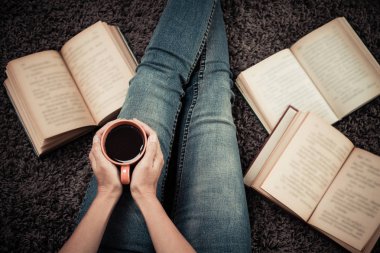 Asyalı kadın ile halı üzerinde oturan kitaplar. Asyalı kadın evde çalışan Üstten Görünüm.