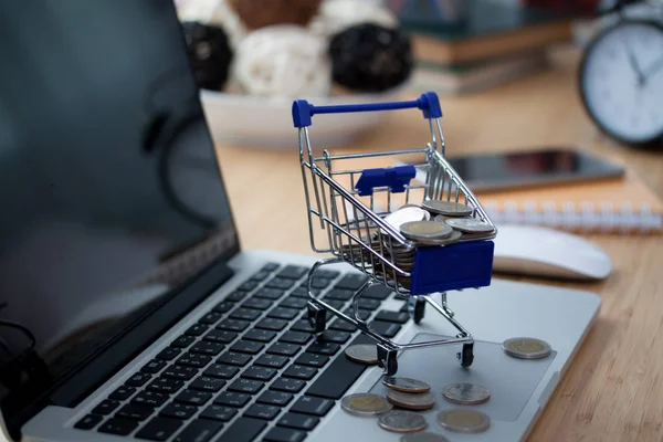 Mini shopping cart on computer laptop. Business concept.