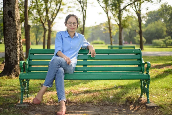 Mujer asiática sentada en el banco en el gargen . — Foto de Stock