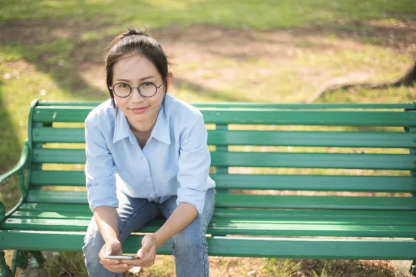 Mujer asiática sentada en el banco en el gargen . — Foto de Stock