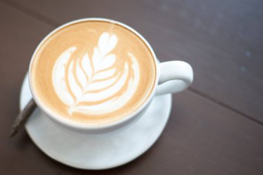 Latte sanat sıcak kahve kahve dükkanında masada.