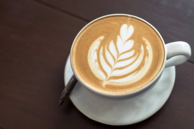Latte sanat sıcak kahve kahve dükkanında masada.