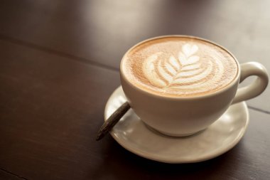 Latte sanat sıcak kahve kahve dükkanında masada.