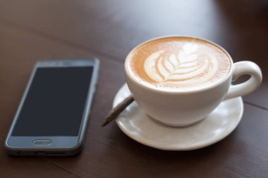 Latte sanat sıcak kahve kahve dükkanında masada.