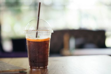 Kafedeki ahşap masada lamonlu buzlu kahve.