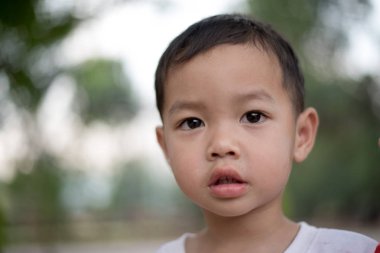 Parkta gülümseyen mutlu Asya çocuğun yakın çekim. Küçük Asyalı çocuk portre fotoğraf Park.