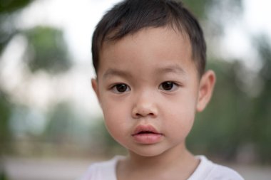 Parkta gülümseyen mutlu Asya çocuğun yakın çekim. Küçük Asyalı çocuk portre fotoğraf Park.