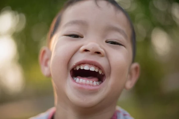 公園で笑っている幸せのアジアの少年のクローズ アップ 公園で少しアジア子供ポートレート写真 ロイヤリティフリーのストック画像