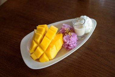 Mango, pirinç, buz çığlığı ve ahşap masaya hindistan cevizi sütüyle kapatılmış..