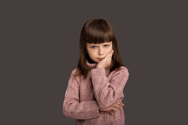 伤心的小女孩 伤心的孩子 讨厌情绪低落的孩子 孤独的概念 面部表情不好的表情 灰色背景的粉色毛衣 — 图库照片