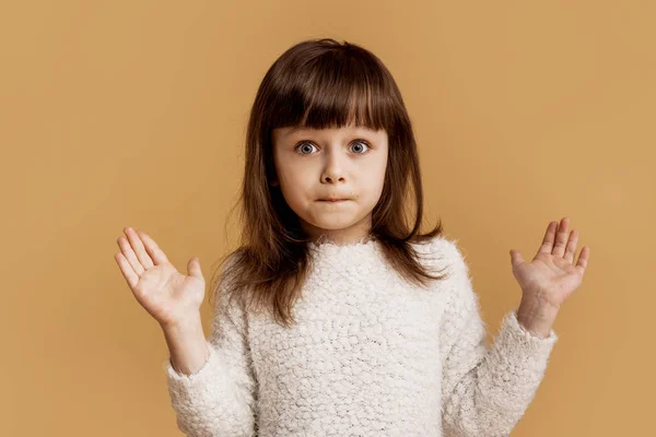 这不是我的 我不知道 有趣的可爱的感情女孩表现出困惑的姿态 迷惑的情绪在脸上 手掌向上 未知的困惑的表情 橙色背景下的一个孩子 — 图库照片