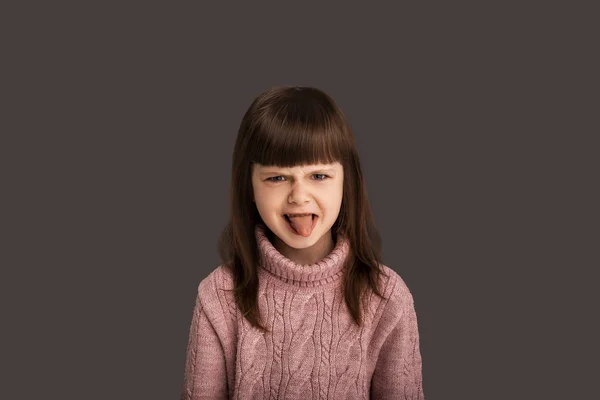 淘气的小女孩在镜头前露出舌头 愤怒的说她不喜欢某样东西 一个不可能取悦的孩子 — 图库照片