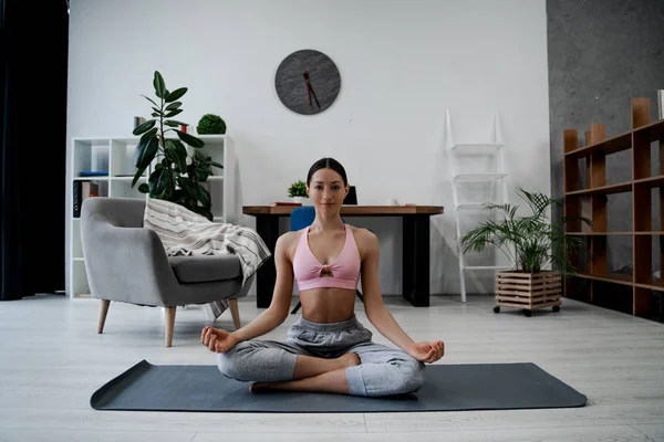 Vakker Sporty Kvinne Mediterer Innendørs Stua Holder Hender Yogabruken Prøver – stockfoto