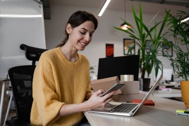 Kendine güvenen güzel bir kadın, genç bir işletme sahibi internet sitesinde satış yapıyor. Çevrimiçi Satış, E-Ticaret, Çevrimiçi İş, posta paketi, çevrimiçi satış, dağıtım konsepti.