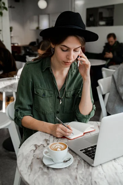 仕事に従事帽子で忙しい忙しい穏やかな女性に集中 フリーランス 起業家 カウリングスペースでの仕事 公共の場所 現代人のライフスタイル ビジネスオンラインコンセプト — ストック写真
