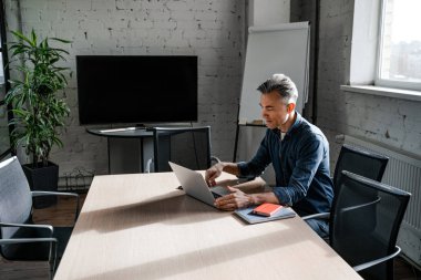 Dizüstü bilgisayarı olan başarılı bir iş adamı. Başarılı iş stratejisi konsepti. Kapalı alanda çalışan kendine güvenen bir ofis çalışanı.