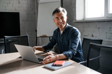 Dizüstü bilgisayarı olan başarılı bir iş adamı. Başarılı iş stratejisi konsepti. Kapalı alanda çalışan kendine güvenen bir ofis çalışanı.