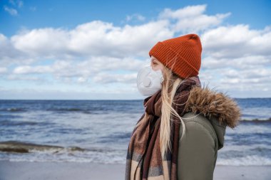 Coronavirus salgını, grip salgını, insanlığın küresel sorunu, maske kıtlığı ve karantinada kalma ihtiyacı. Arka planda deniz, seyahat iptali ve kapalı sınırlar.