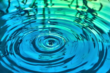 Yağmur damlaları suyun yüzeyine düşer.