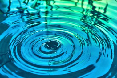 Yağmur damlaları suyun yüzeyine düşer.