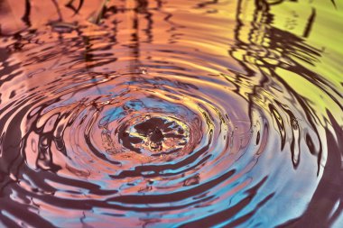 Yağmur damlaları suyun yüzeyine düşer.