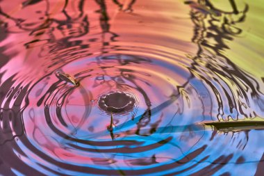 Yağmur damlaları suyun yüzeyine düşer.