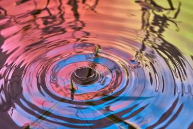 Yağmur damlaları suyun yüzeyine düşer.