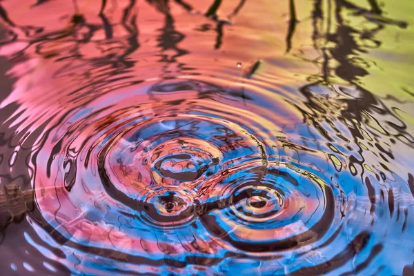 Raindrops fall on the surface of the water