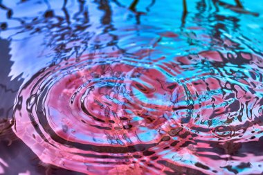 Yağmur damlaları suyun yüzeyine düşer.