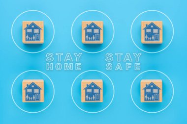 Evde güvende ol, COVID-19 Coronavirus 'a karşı kendini izole etme konsepti. Tahta küplerde ev imajı, birbirinden ayrı, enfeksiyon önleme konsepti.