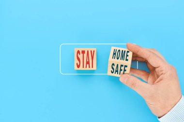 Korunmak için konsept ncov-19 Coronavirus. Bir adamın elindeki tahta bir küp yazıtları oluşturur. Evde güvende kal..