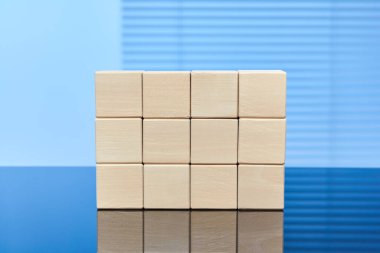 Mavi arka planda on iki tahta küp üç sıra üstte duruyor. Harfler, sayılar, semboller veya etiketler için boş alan. Bilgi grafikleri için düzenName.