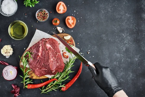 Butcher Holds Knife Piece Fresh Meat Tenderloin Lies Parchment Dark — Stock Photo, Image