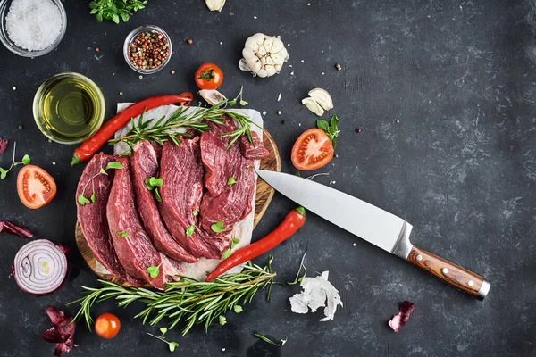 Skivning Portionerade Nötkött Biffar Ligger Pergament Och Skärbräda Mörk Bakgrund — Stockfoto